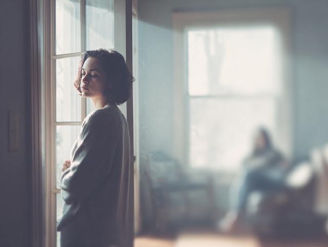 a person at home opening a window to avoid cigarette smoke